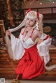 A woman in a red and white dress sitting on a wooden floor.