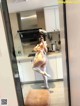 A woman taking a selfie in a mirror in a kitchen.