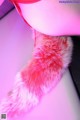 A close up of a pink and white fur tail.