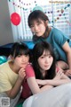 A group of young women sitting on top of a bed.